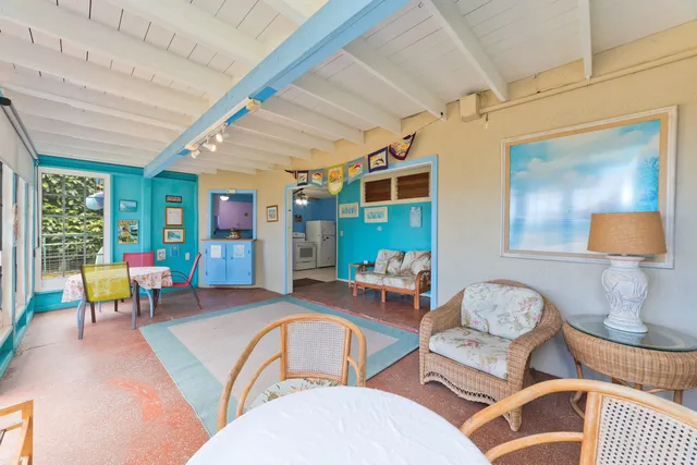 a view of a livingroom with furniture and a refrigerator