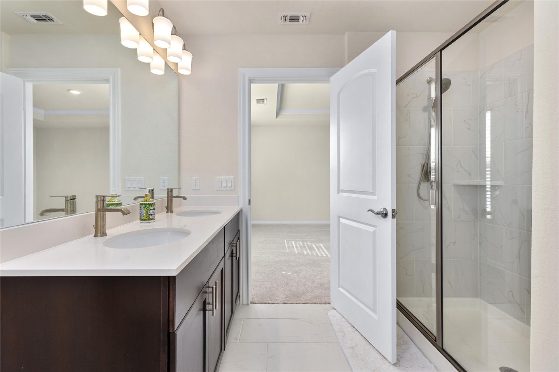5513 Durango Pass Austin, TX 78724 - Photo 21 of 31 a bathroom with a double vanity sink mirror and shower