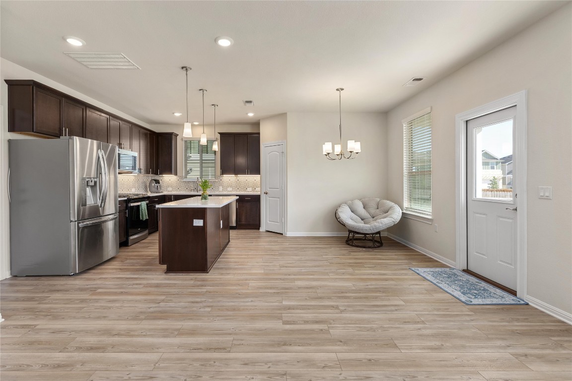 5513 Durango Pass Austin, TX 78724 - Photo 8 of 31 a kitchen with stainless steel appliances kitchen island granite countertop a refrigerator a sink a stove and a wooden floors