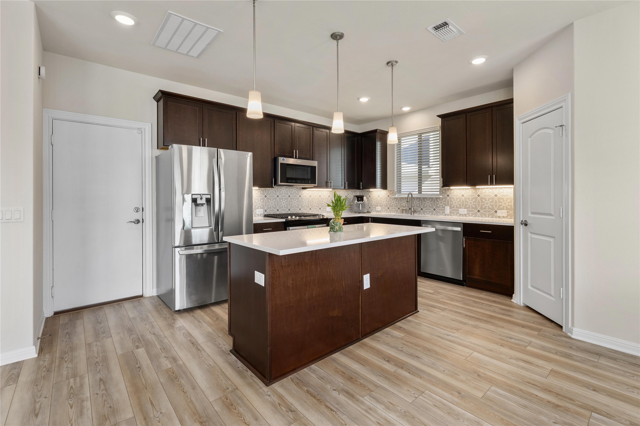 5513 Durango Pass Austin, TX 78724 - Photo 9 of 31 a kitchen with kitchen island stainless steel appliances a sink cabinets and wooden floor