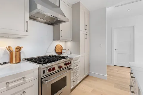 a kitchen with stainless steel appliances granite countertop a stove and a wooden cabinets