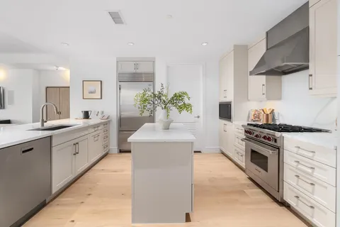 a large kitchen with stainless steel appliances granite countertop a lot of counter space and a sink