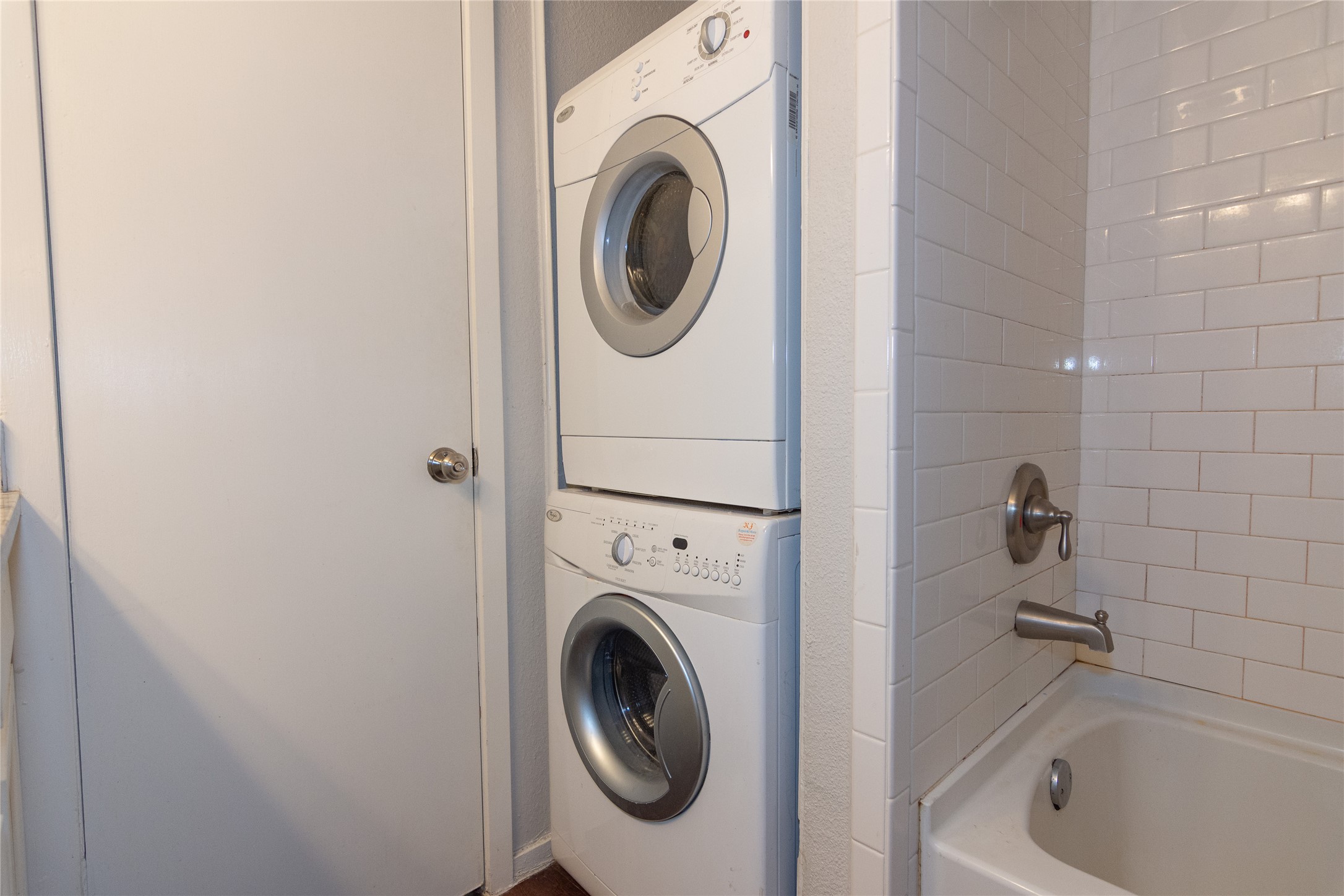 3115 Helms Street, Unit 106 Austin, TX 78705 - Photo 7 of 7 A convenient stacked washer and dryer unit complements a tiled tub/shower combination.
