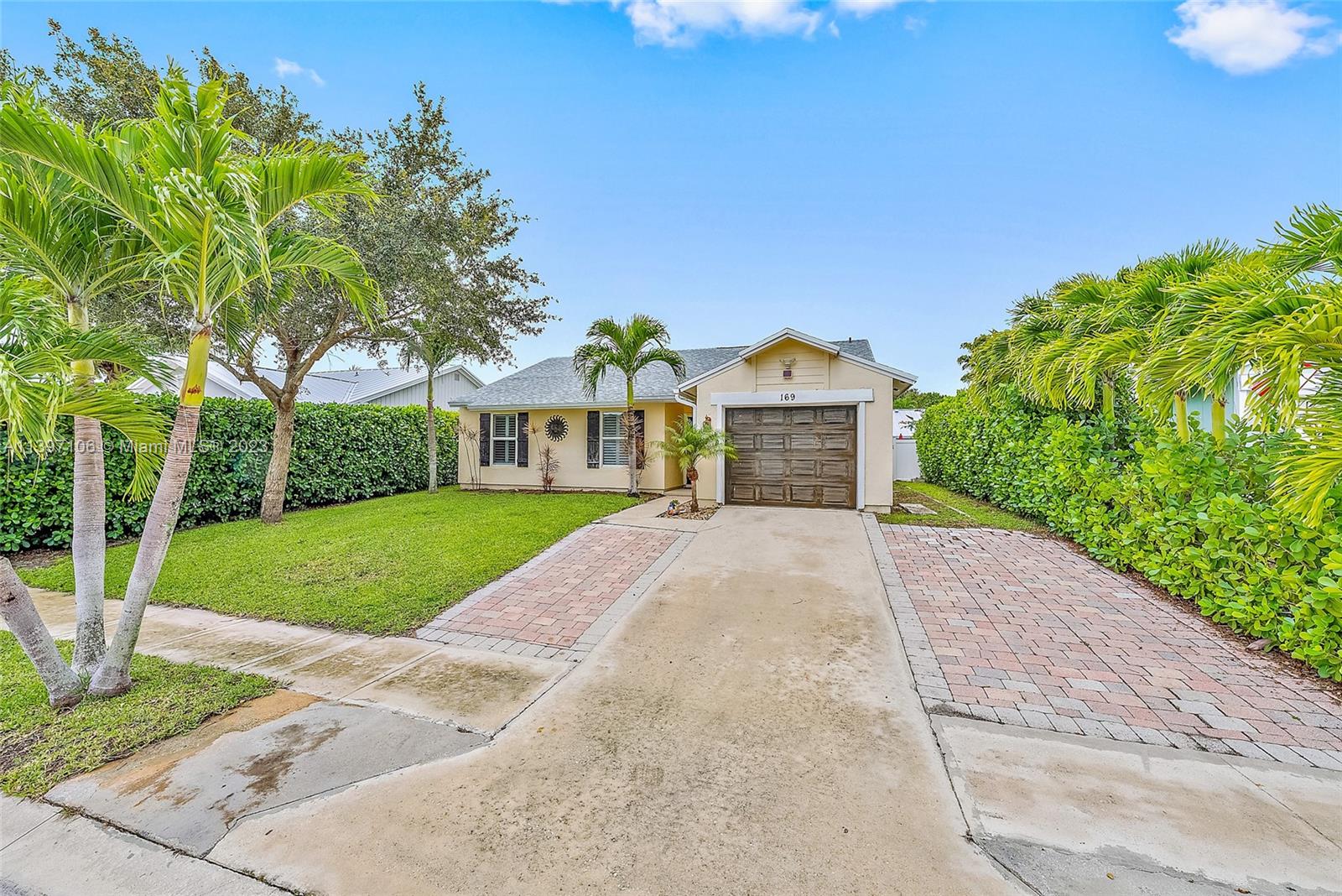 169 Greentree Circle Jupiter, FL 33458 - Photo 2 of 38 a front view of a house with a yard and garage