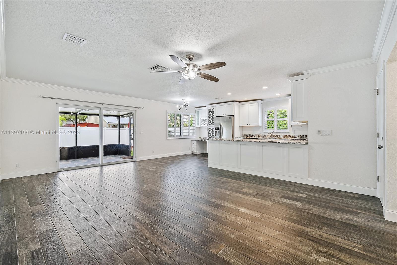 169 Greentree Circle Jupiter, FL 33458 - Photo 4 of 38 a view of an empty room with a kitchen stove and wooden floor