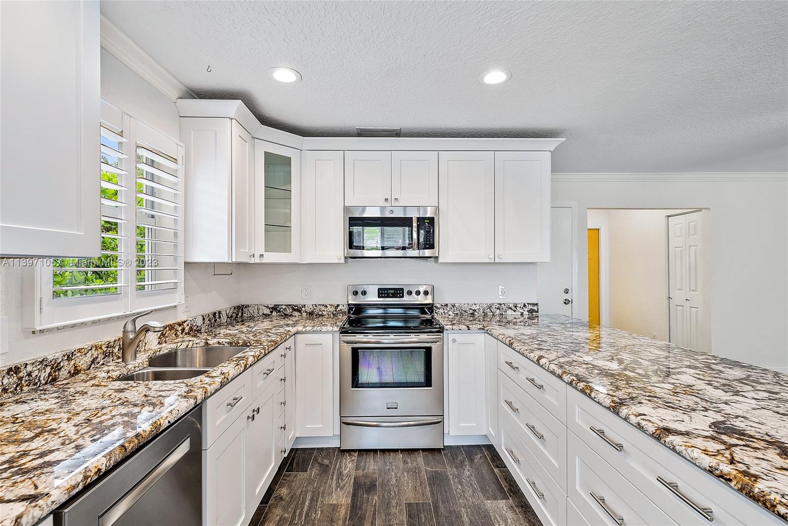 169 Greentree Circle Jupiter, FL 33458 - Photo 8 of 38 a kitchen with granite countertop white cabinets and appliances