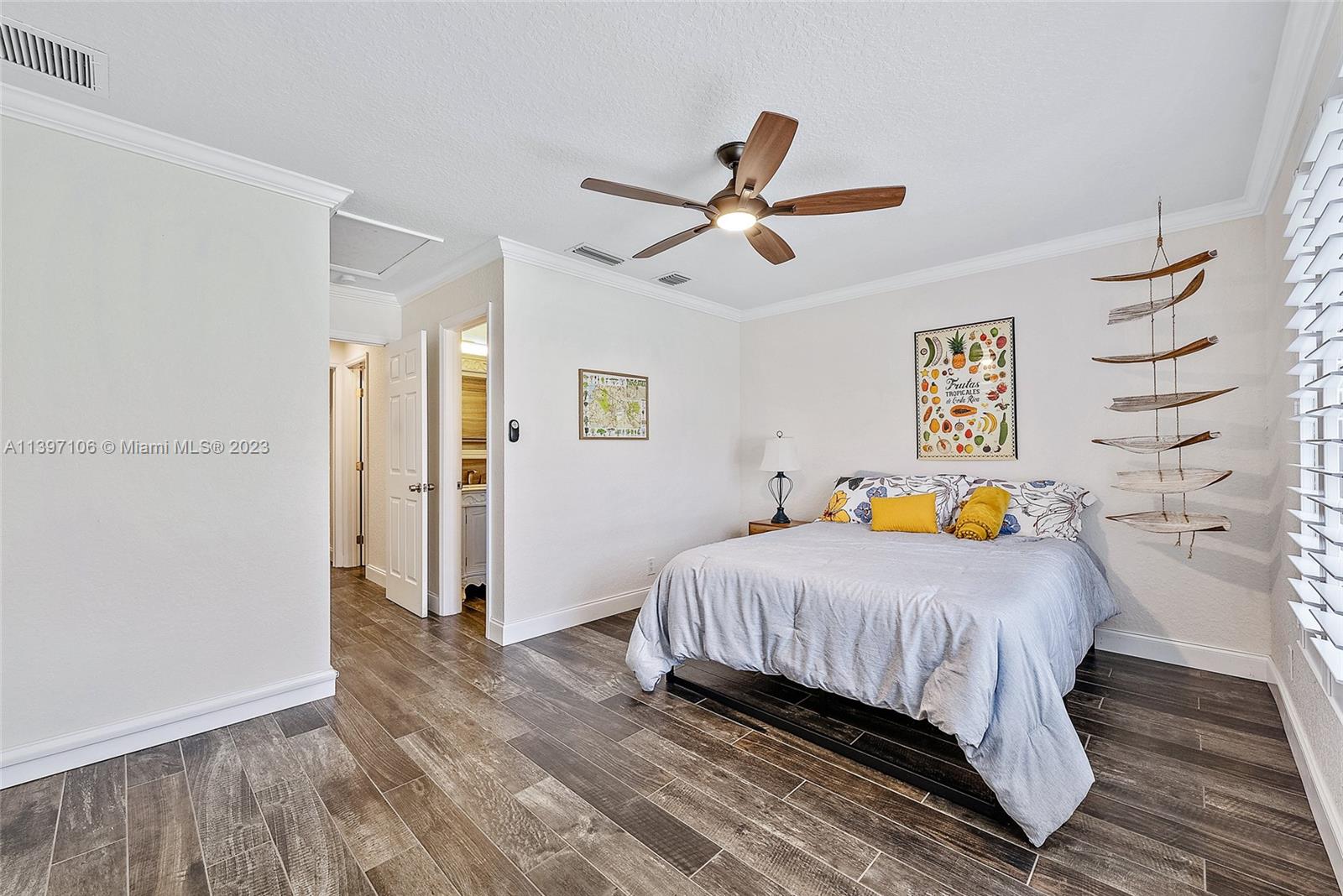 169 Greentree Circle Jupiter, FL 33458 - Photo 10 of 38 a bedroom with a bed a window and a ceiling fan