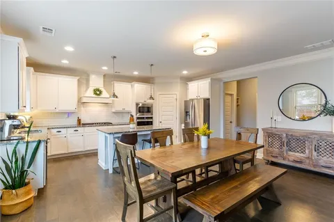 a kitchen with granite countertop a table chairs microwave and cabinets