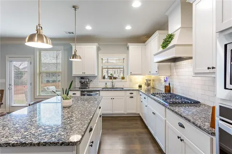 a kitchen with stainless steel appliances kitchen island granite countertop a refrigerator and a stove