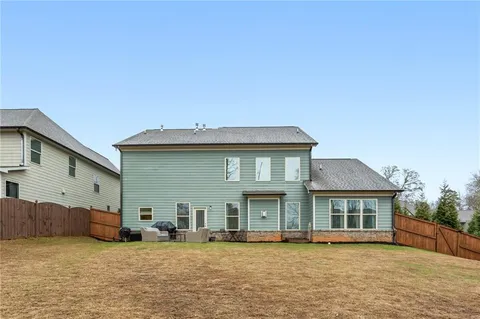 a backyard of a house with basket ball court tables and chairs