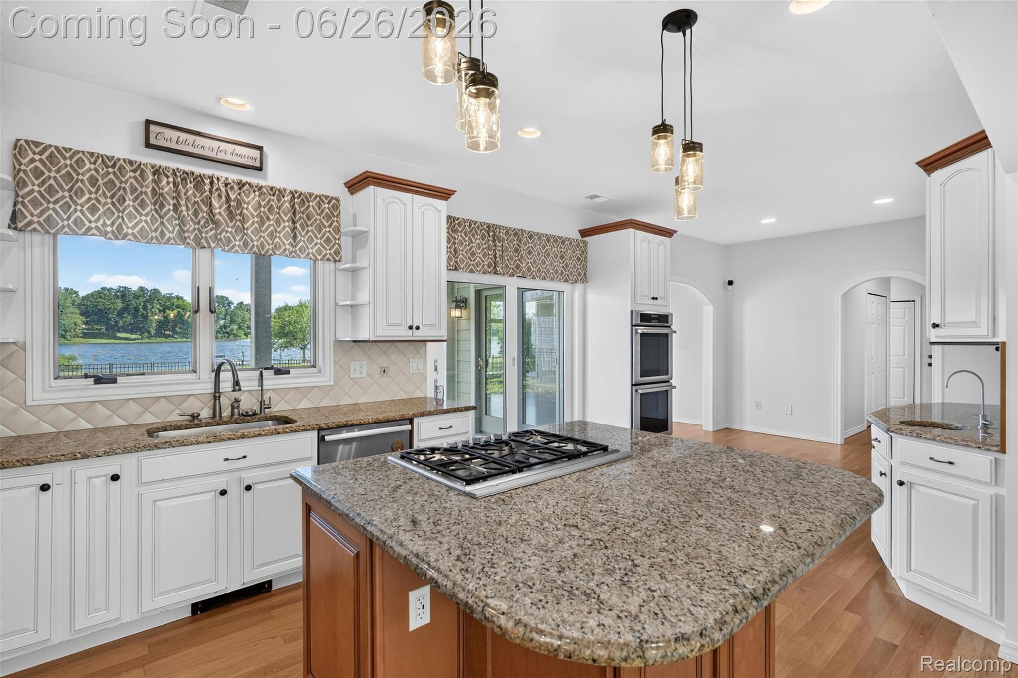 3478 Lexington Road Waterford, MI 48328 - Photo 8 of 52 Spacious kitchen featuring an expansive island with gas cooktop, built-in double ovens, and wood-finish flooring