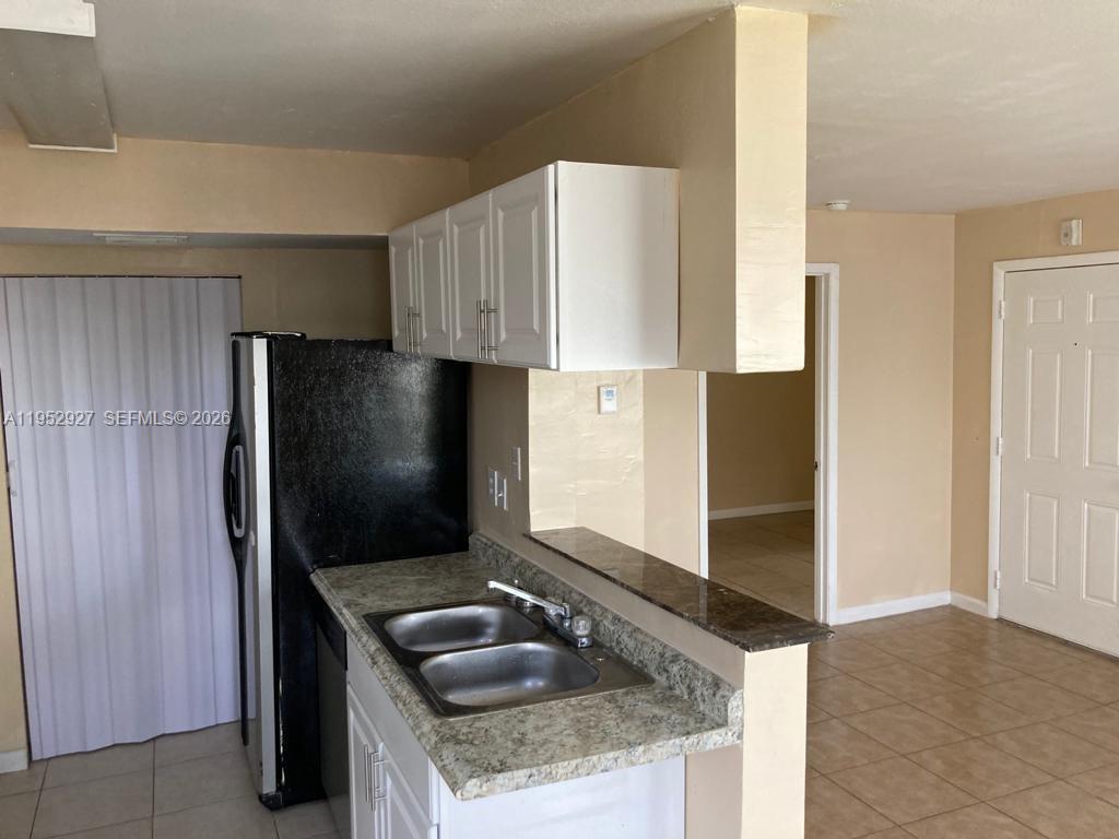 8705 Northwest 39th Street Sunrise, FL 33351 - Photo 3 of 13 a kitchen with granite countertop a sink and a refrigerator
