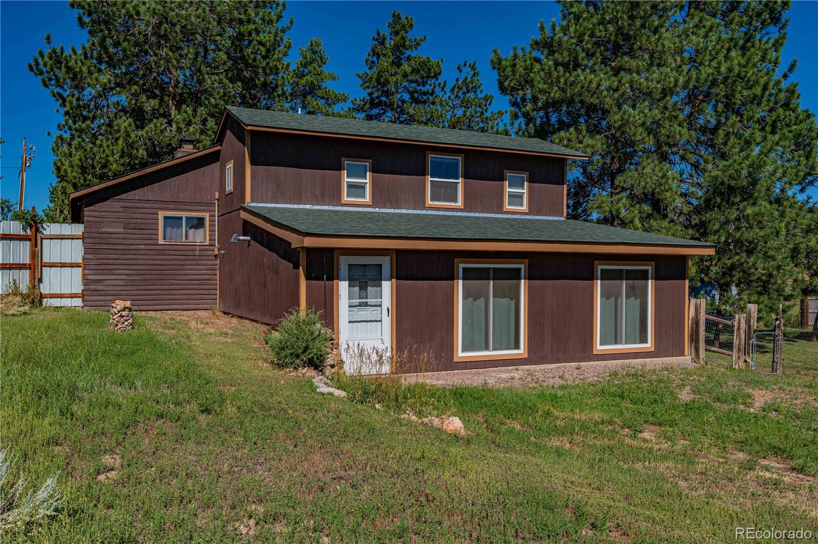 2925 M Path Cotopaxi, CO 81223 - Photo 2 of 50 a brick house with a small yard and large trees