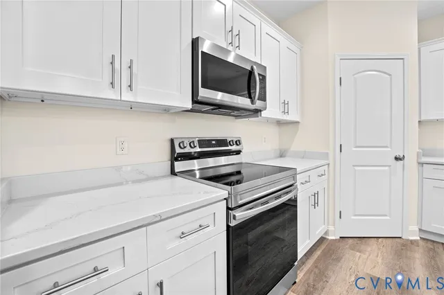 a kitchen with white cabinets stainless steel appliances and sink