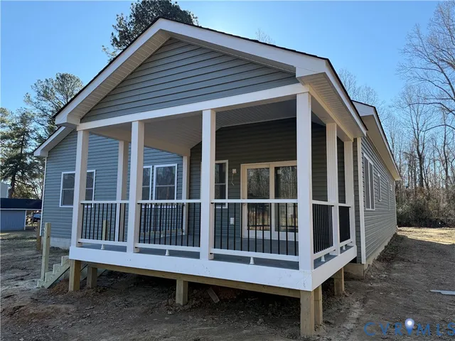 a porch with a bench next to a yard