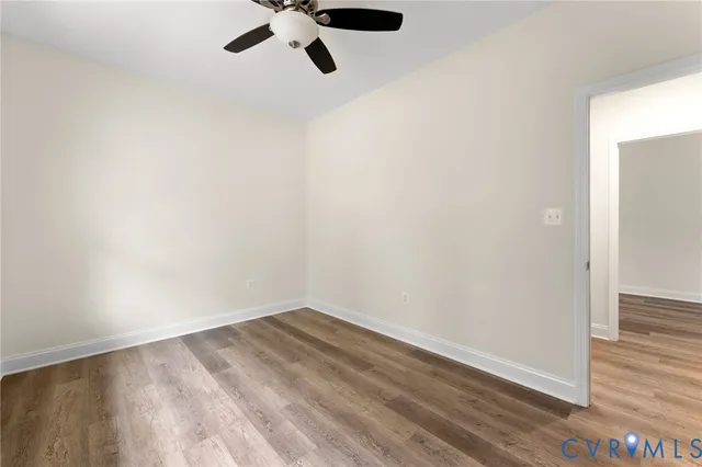 a view of a room with wooden floor and ceiling fan
