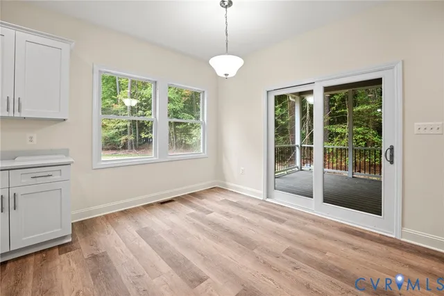 a view of a bedroom with wooden floor and windows