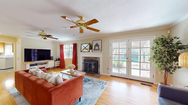 a living room with furniture fireplace and a large window