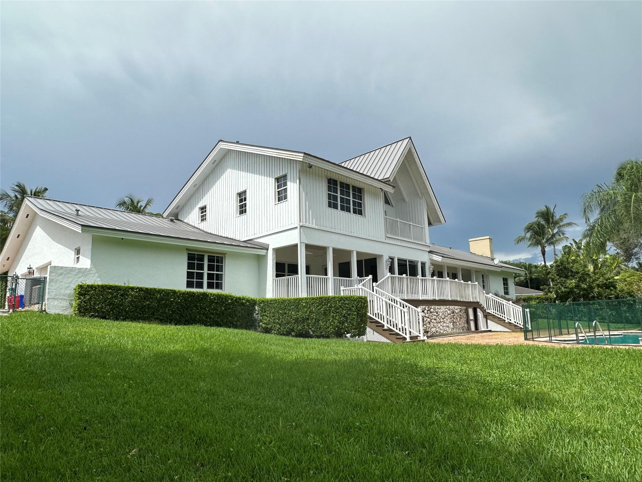 a view of a house with a big yard and large trees