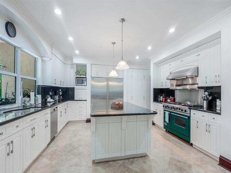 441 Ridge Road Coral Gables, FL 33143 - Photo 13 of 23 a kitchen with stainless steel appliances kitchen island a refrigerator sink and cabinets