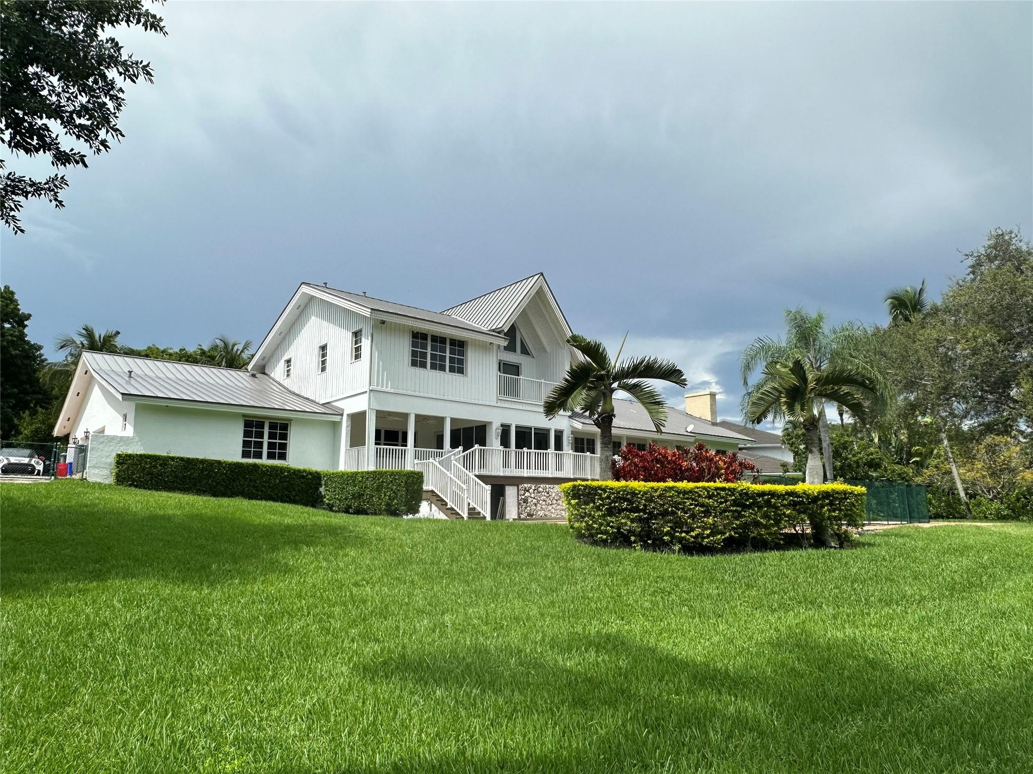 441 Ridge Road Coral Gables, FL 33143 - Photo 2 of 23 a front view of a house with a garden and trees