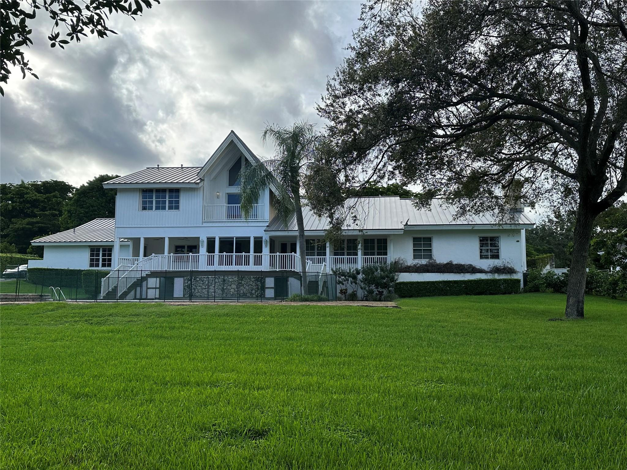 441 Ridge Road Coral Gables, FL 33143 - Photo 4 of 23 a view of a house with a big yard potted plants and a large tree