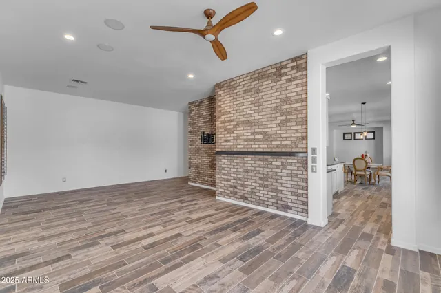 a view of an empty room with window and wooden floor