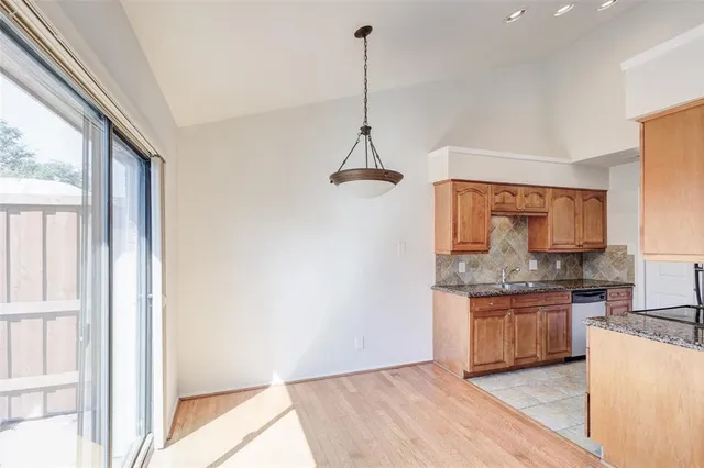 a kitchen with kitchen island granite countertop a sink cabinets and wooden floor