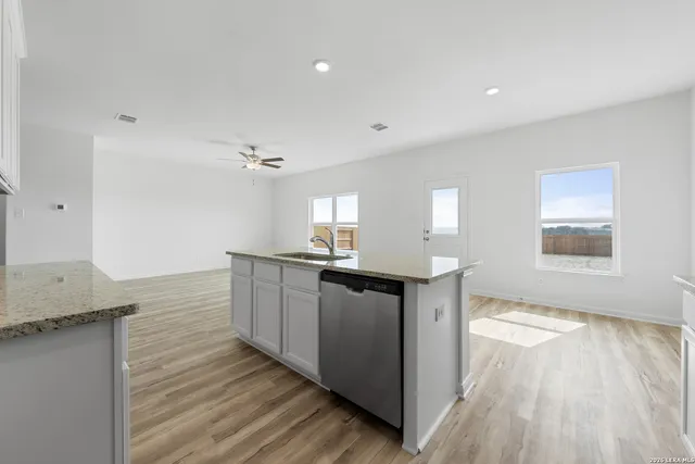 a kitchen with granite countertop a sink and a stove top oven