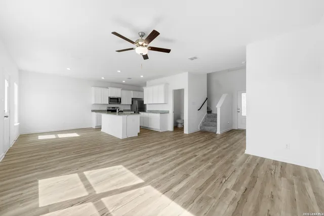 a view of a kitchen with refrigerator and white cabinets