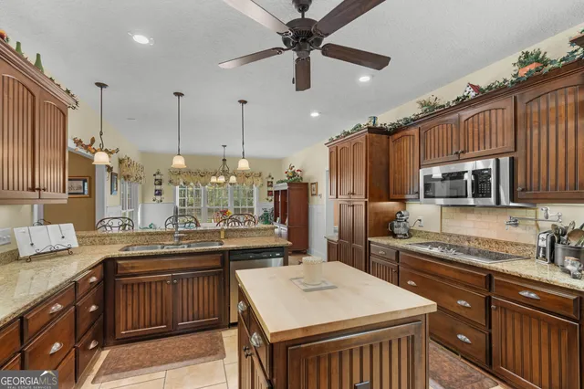 a kitchen with stainless steel appliances granite countertop a refrigerator and a stove top oven