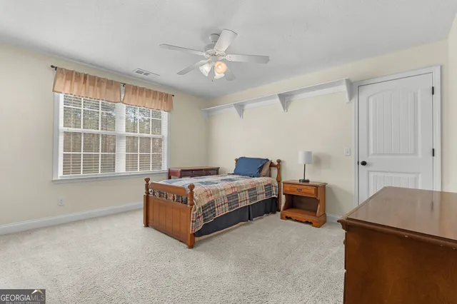 a spacious bedroom with a bed and a chandelier