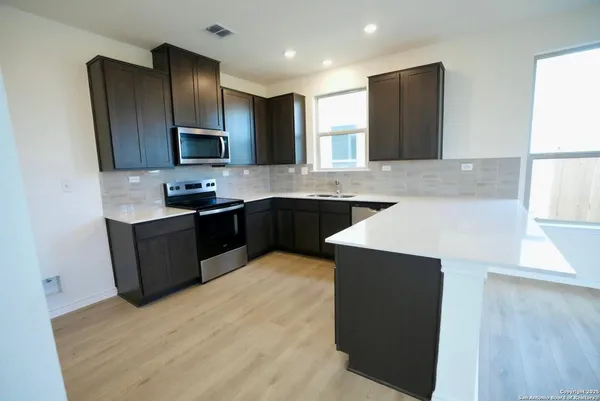 a kitchen with a sink a stove a refrigerator and a microwave