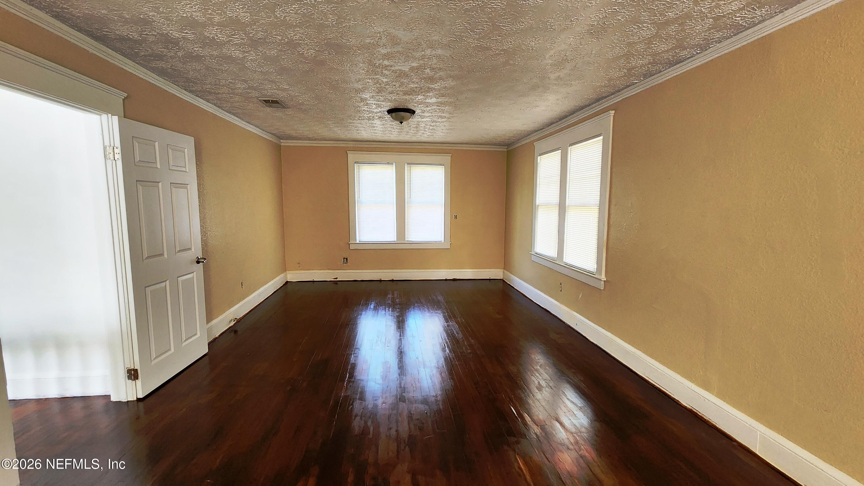 2036 Moncrief Road Jacksonville, FL 32209 - Photo 13 of 32 a view of an empty room with wooden floor and window