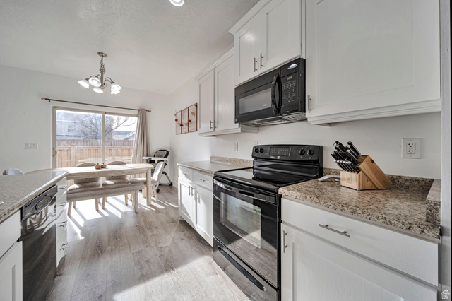 11730 South Shadow Lane Draper, UT 84020 - Photo 10 of 24 Kitchen with black appliances, white cabinetry, suspended lighting, and light wood-style floors