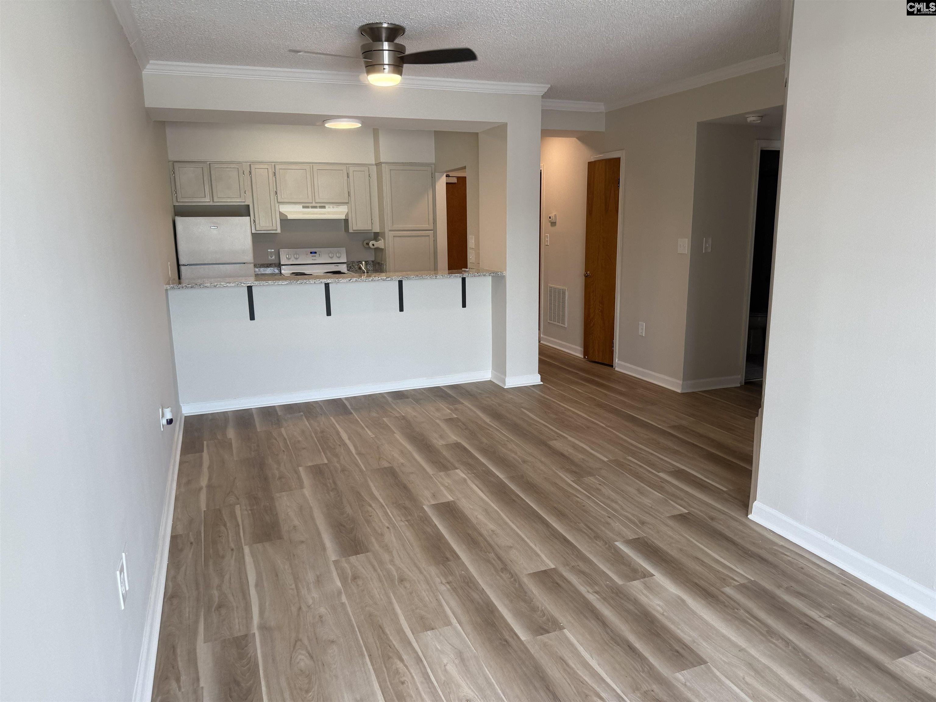 2002 Greene Street, Unit 209 Columbia, SC 29205 - Photo 6 of 22 a view of a room with wooden floor and a ceiling fan