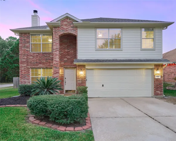 a view of a brick house with a yard and plants