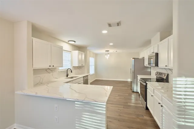 a large kitchen with kitchen island a sink stainless steel appliances and cabinets