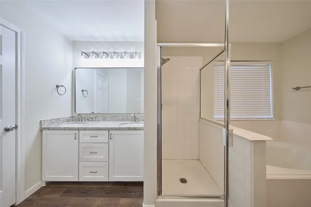 a bathroom with a granite countertop sink a mirror and a shower