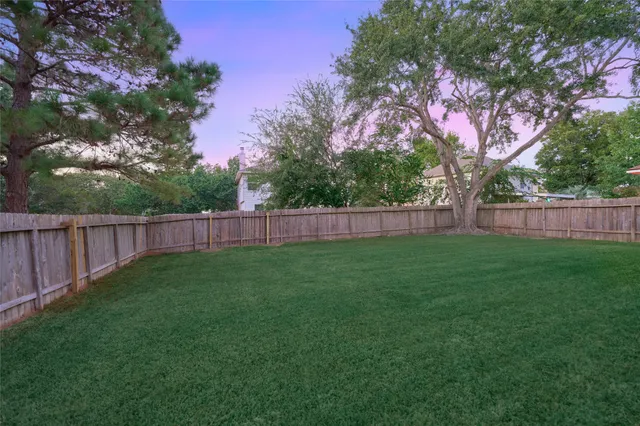 a view of yard with green space and wooden fence