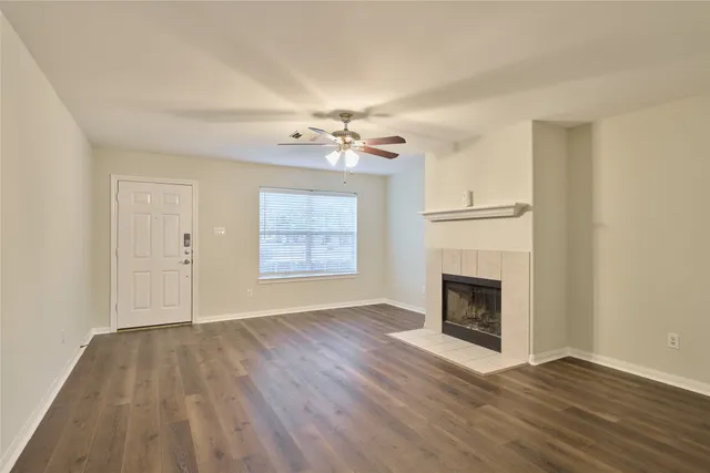 wooden floor fireplace and windows in an empty room