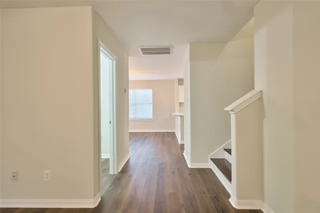 a view of a hallway with wooden floor
