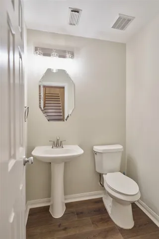a bathroom with a toilet sink and mirror
