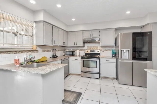 a kitchen with a stove a sink and a refrigerator