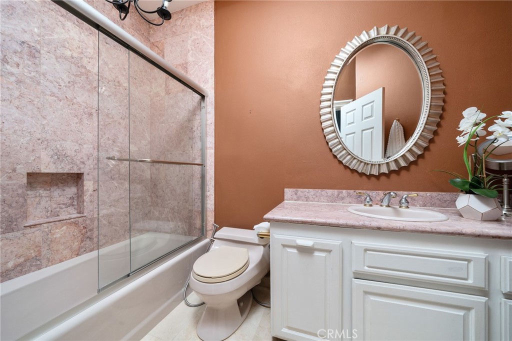 275 East 24th Street Upland, CA 91784 - Photo 32 of 74 a bathroom with a toilet a sink and mirror