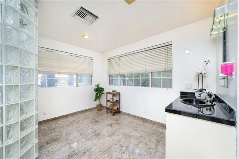 a view of a white house with a large windows and flower plants