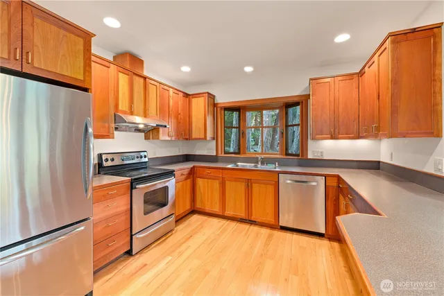 a kitchen with stainless steel appliances granite countertop a refrigerator sink and cabinets