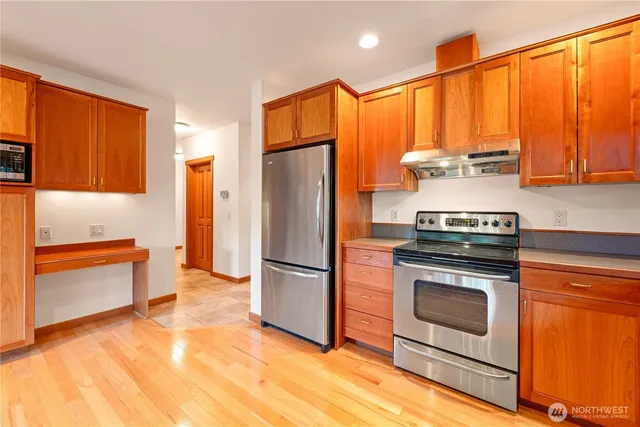 a kitchen with stainless steel appliances a stove a refrigerator and a sink