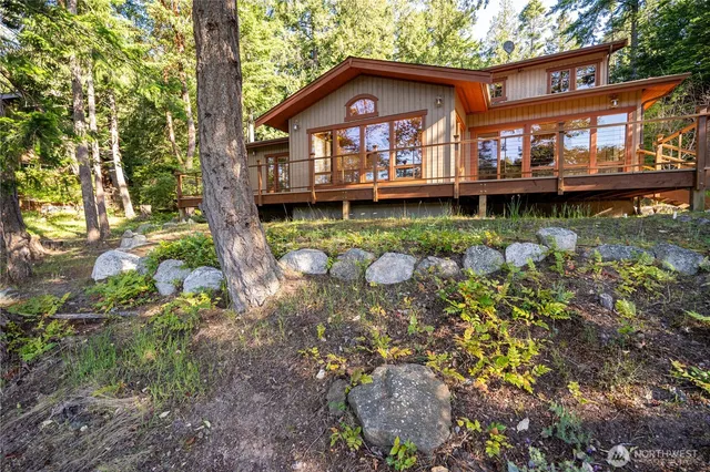 a front view of a house with a garden and a wooden deck