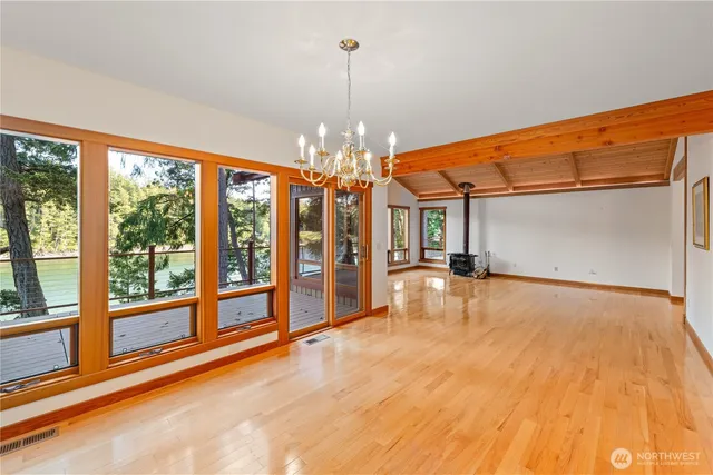 a view of empty room with chandelier fan and windows